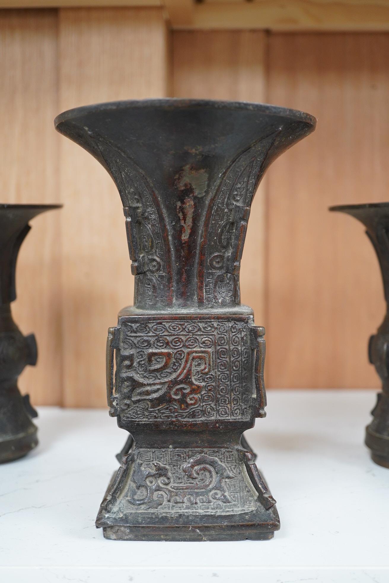 A pair 17th/18th century Chinese archaistic bronze gu vases, and a similar square vase, fanggu, Ming dynasty, tallest 18cm. Condition - poor to fair